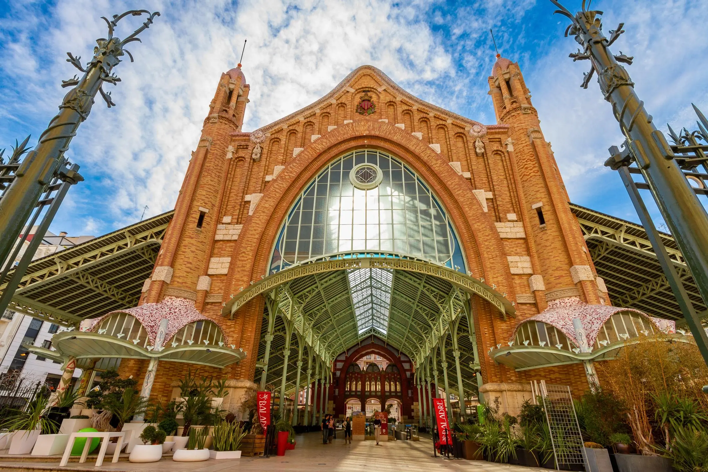The grand brick and iron facade of Mercado de Colón in Valencia