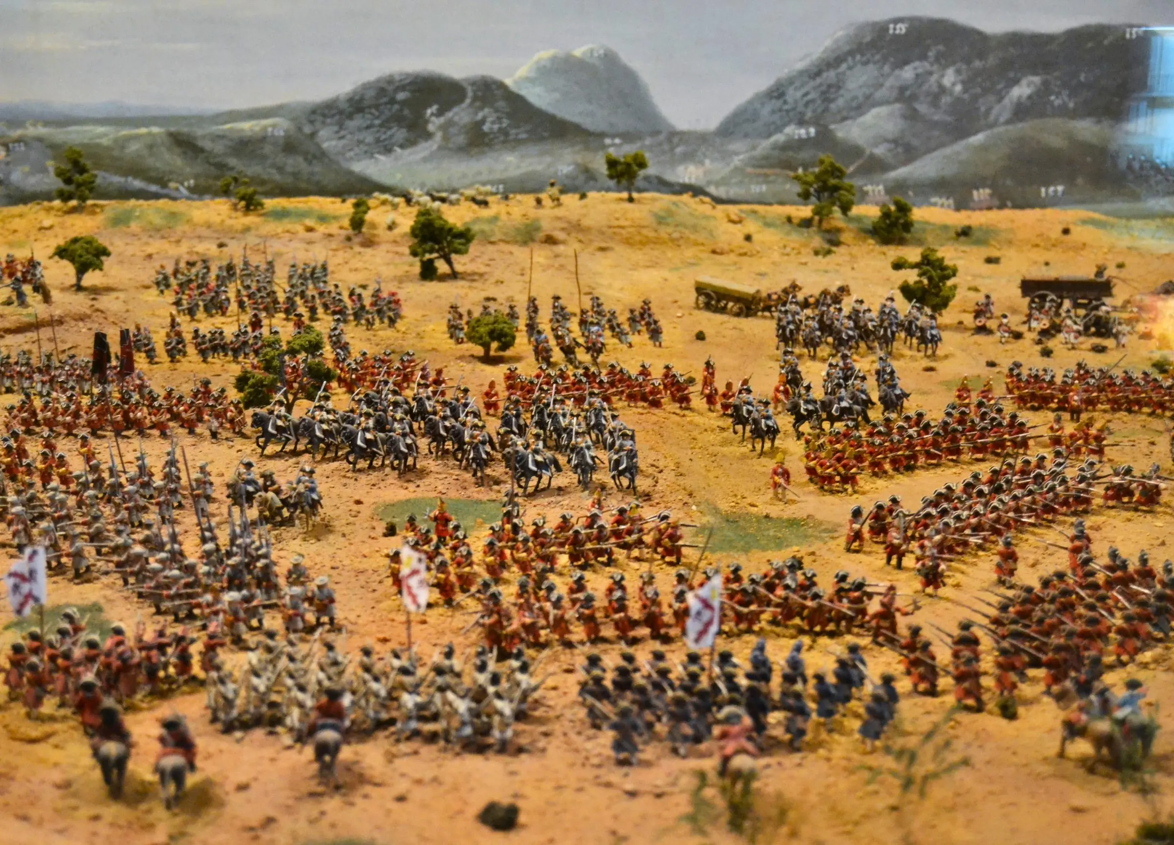 Thousands of miniature lead soldiers arranged in battle formation on a desert terrain diorama