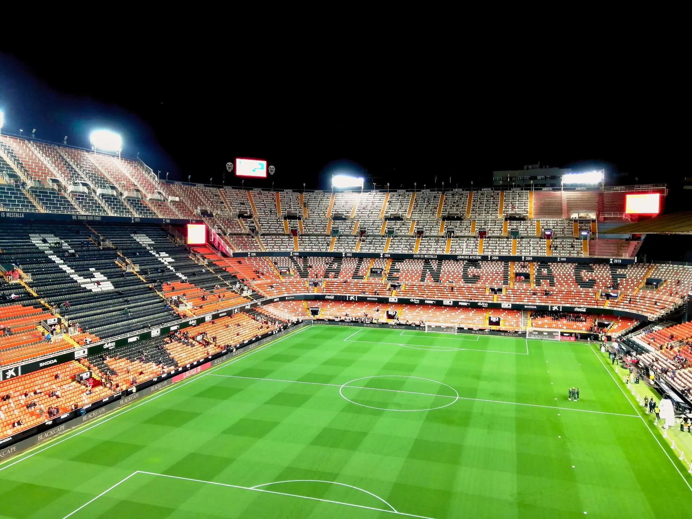 The steep orange and black seating of Mestalla Stadium in Valencia